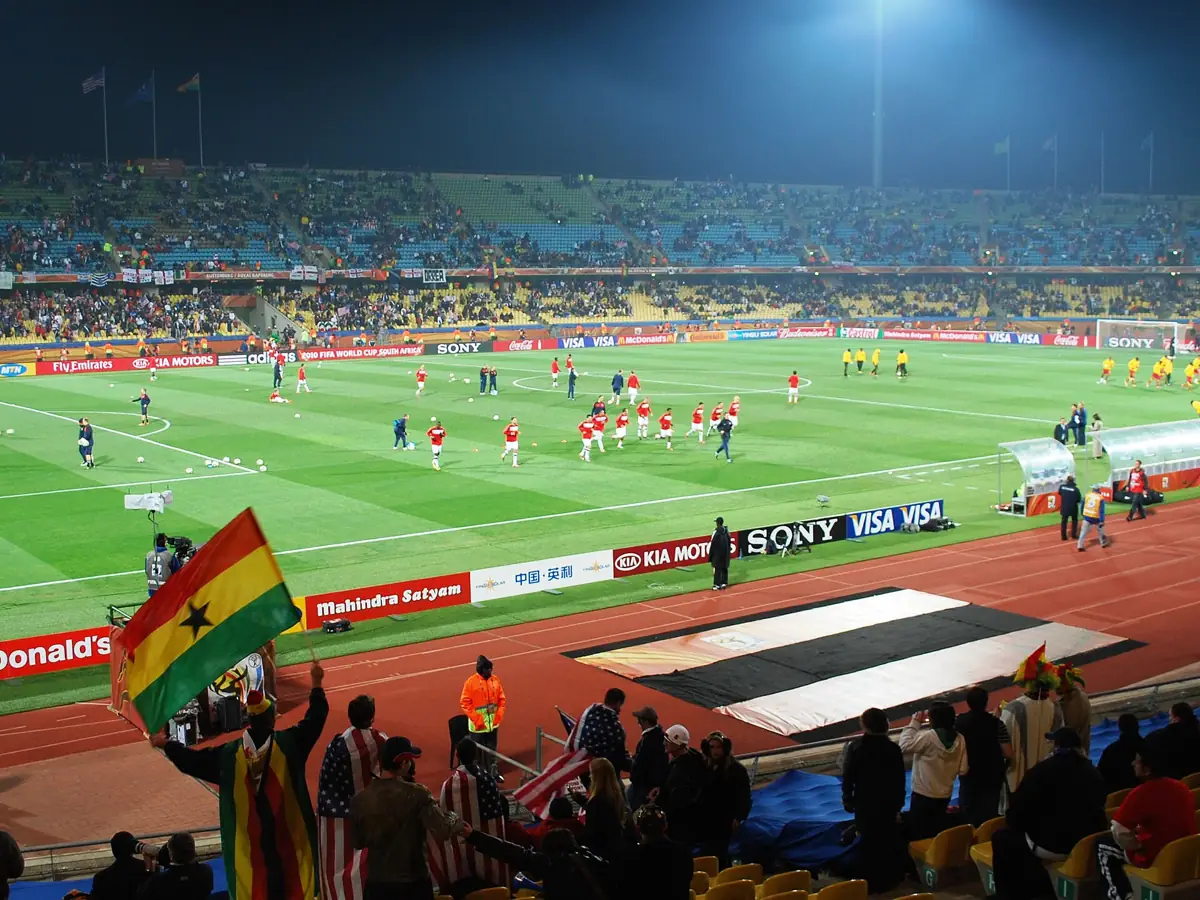 Players on the pitch and a Ghana flag during the USA-Ghana World Cup match in South Africa in 2010