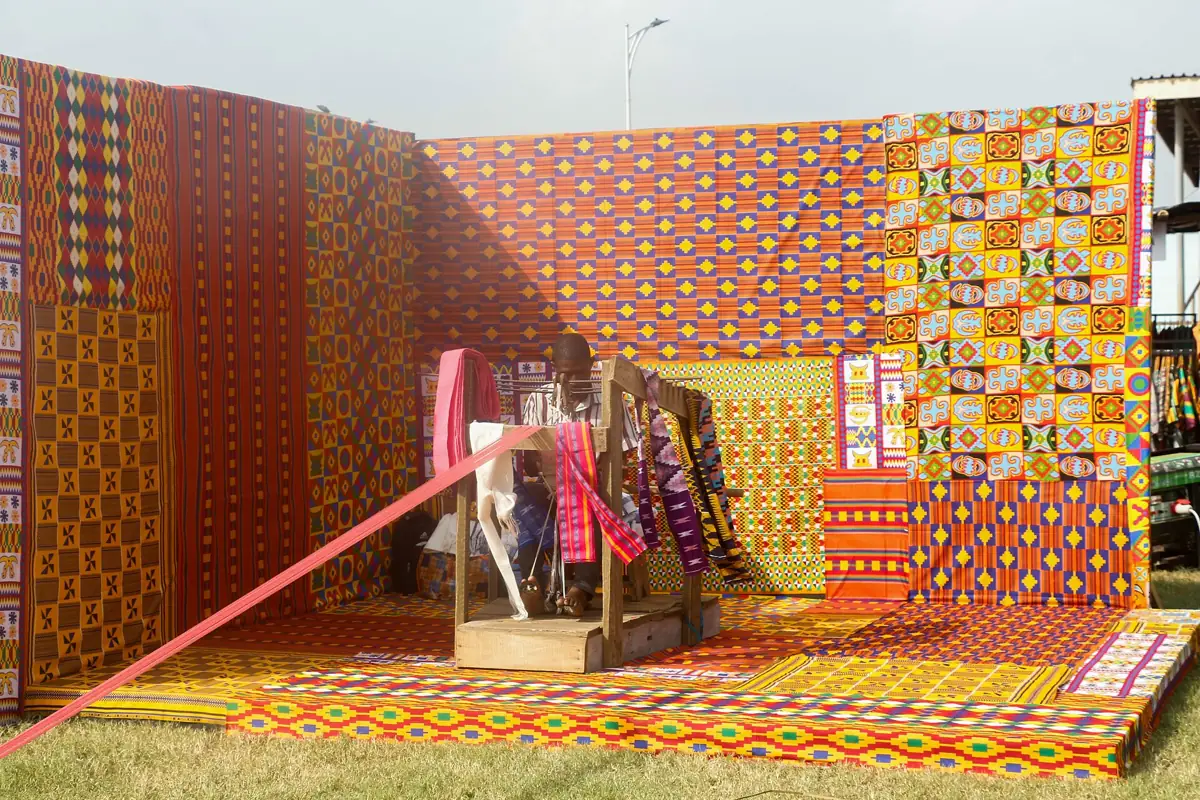 A man weaving colourful Kente cloth at Afrochella Festival in Ghana